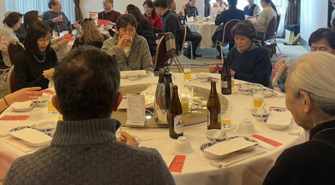 横浜中華街の重慶飯店本館（ローズホテル）での食事風景です。令和8年（2026年)1月、岩本町三丁目町会の日帰りバス旅行のランチの風景です。円卓に大勢の人が座り、美味しい中華料理が出てくるのを今や遅しと待っているところです。