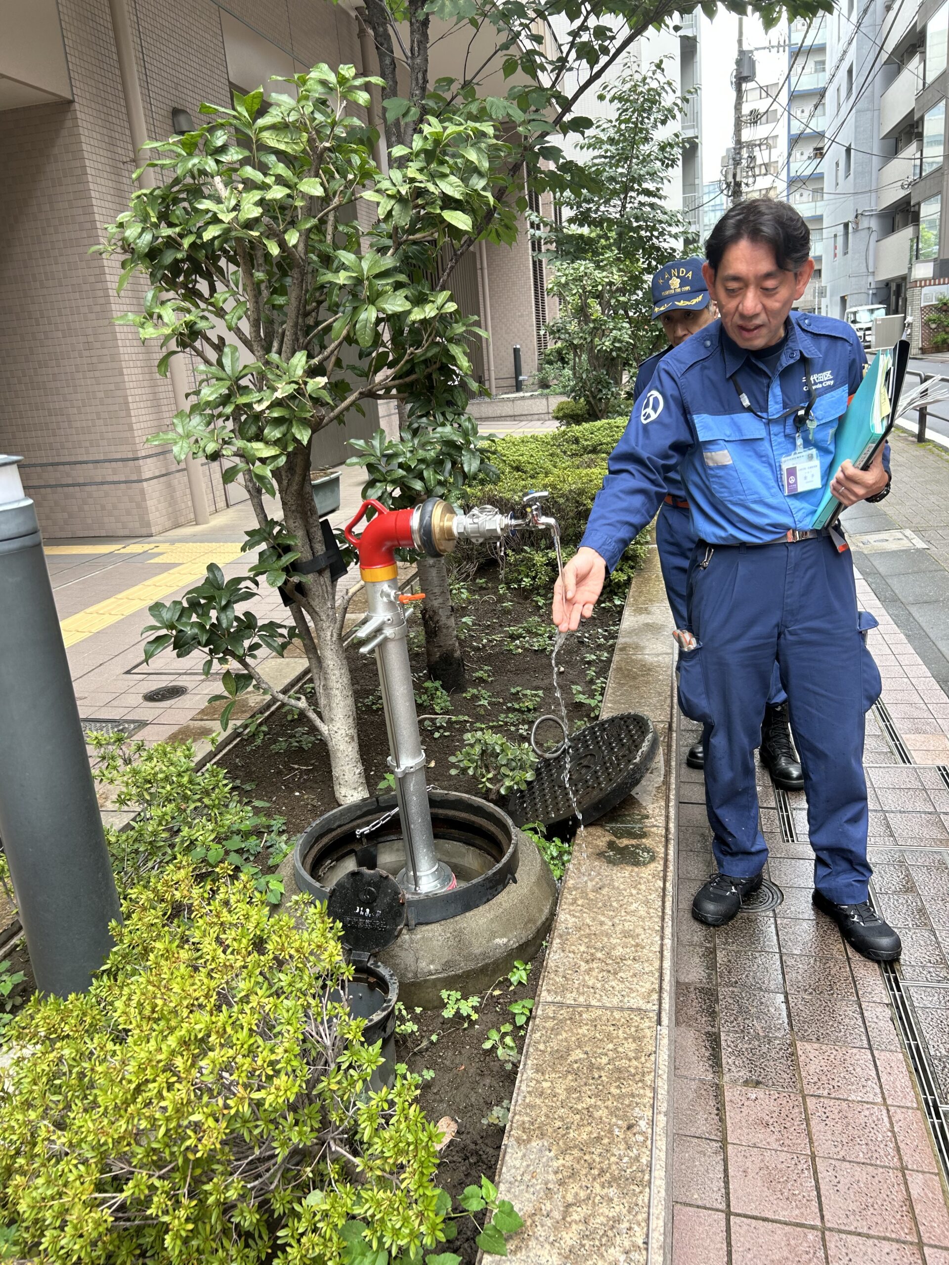 災害時に神田岩本町そして岩本町三丁目等の住民のために開設される「岩本町ほほえみプラザ」避難所の開設訓練で設置された給水管の写真です。地下上水道に給水管をつないで使用します。