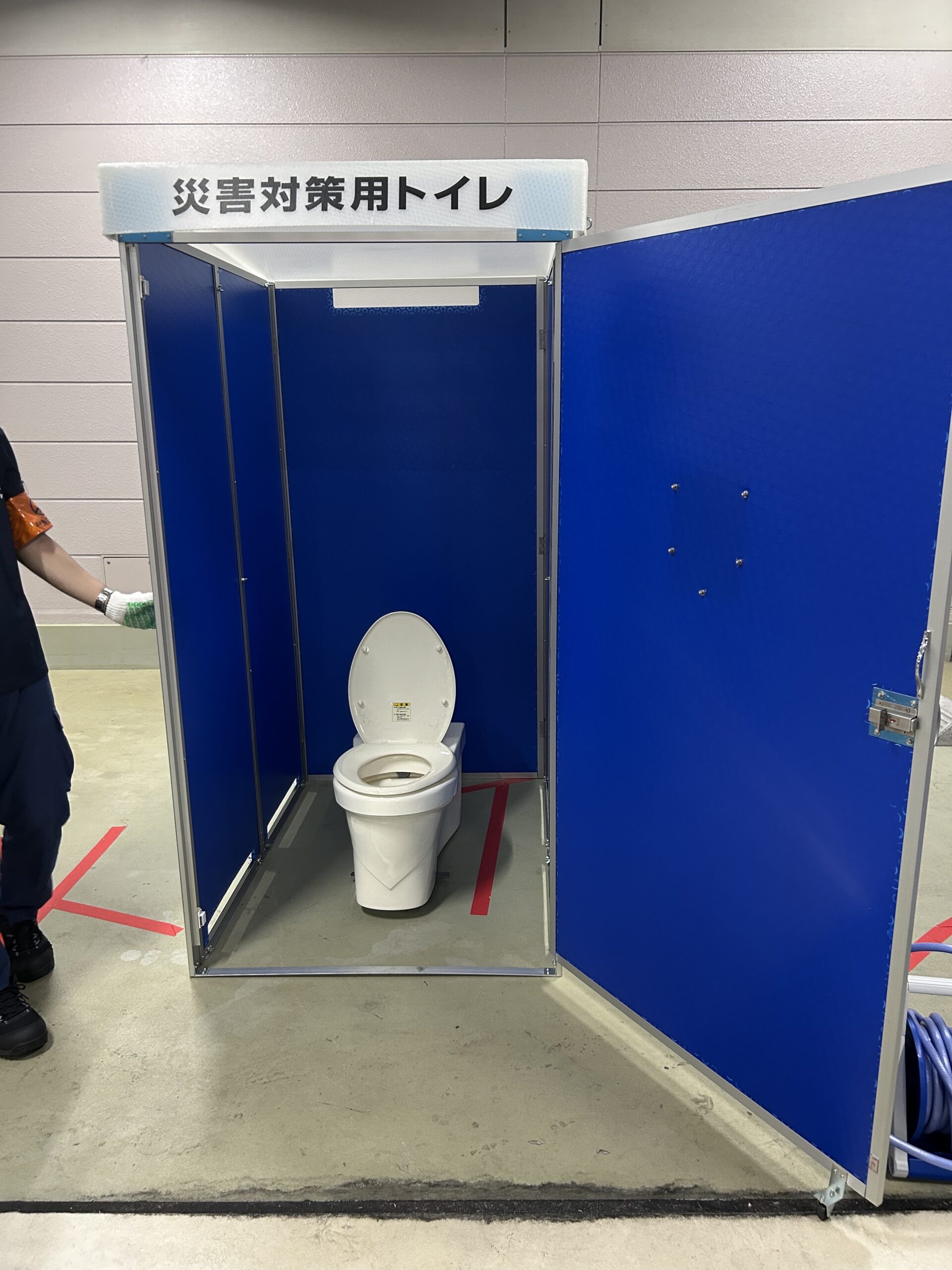 災害時に神田岩本町そして岩本町三丁目等の住民のために開設される「岩本町ほほえみプラザ」避難所の開設訓練で災害用トイレの写真です。どこでも設置できる携帯トイレです。